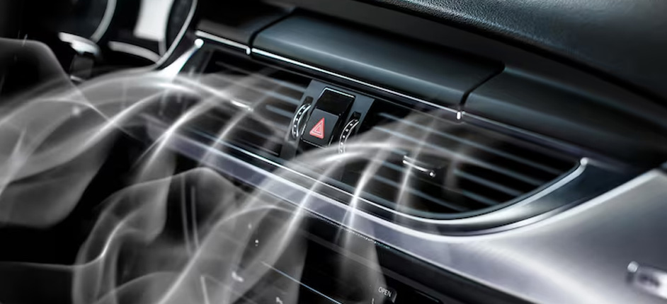 Detailer spraying deodorizing solution onto cloth seats to address lingering smoke smells